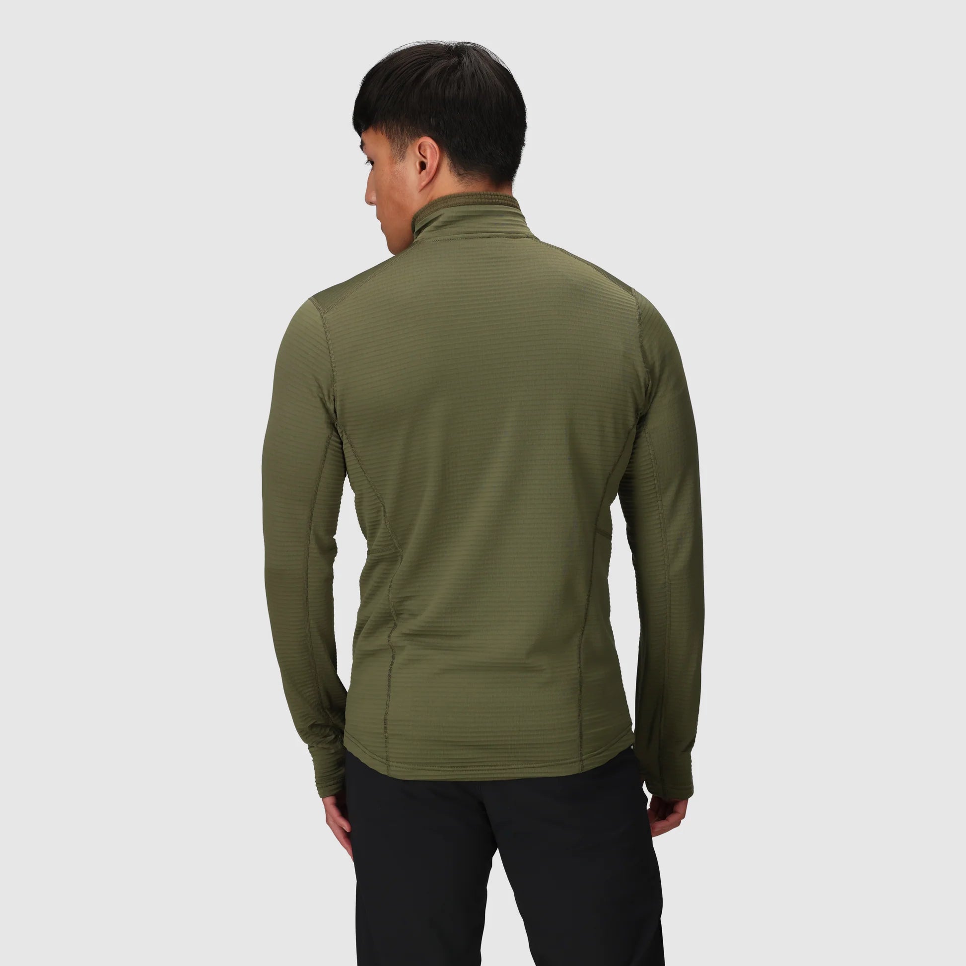 Person wearing a green jacket on a light gray background