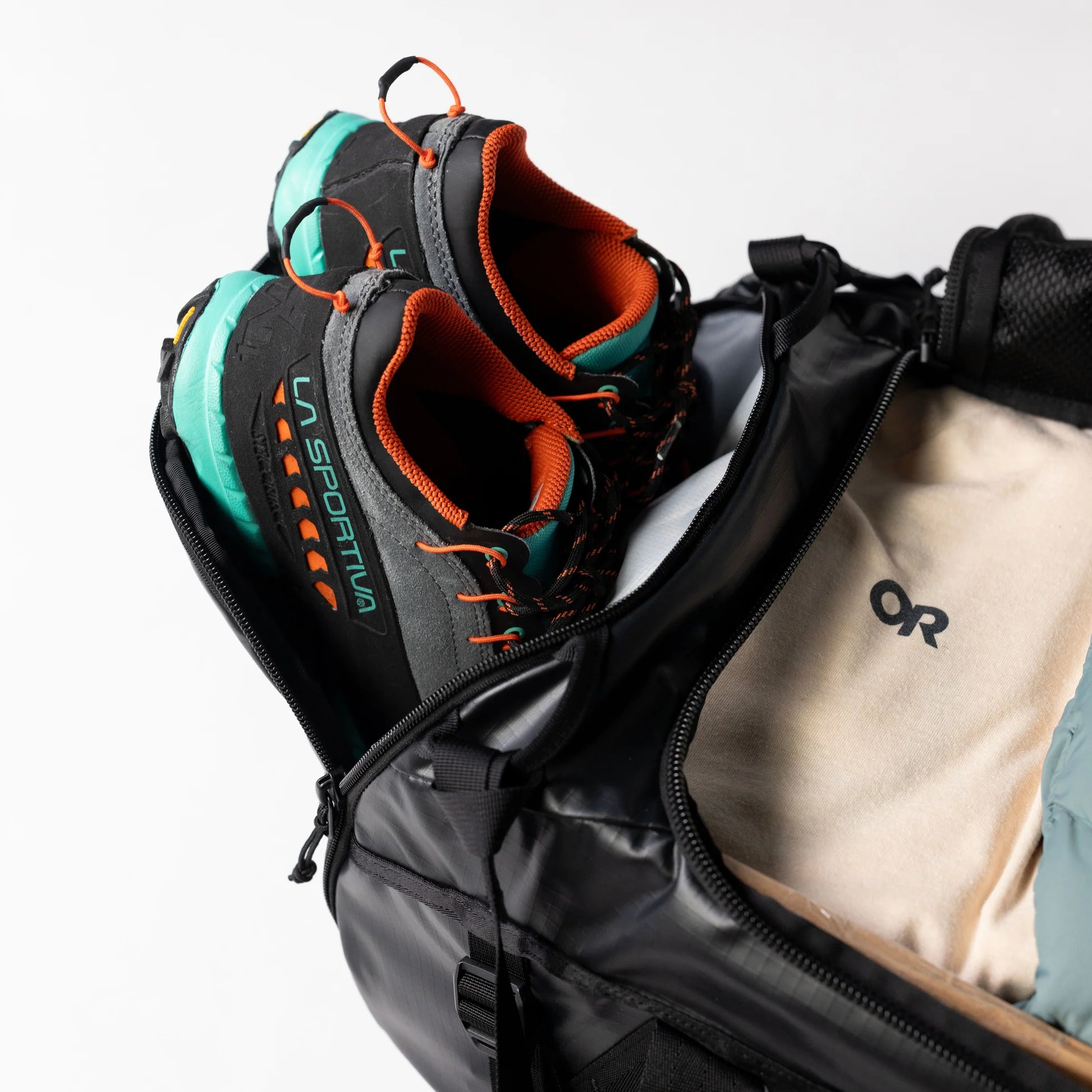 La Sportiva hiking boots inside an open backpack with a visible OR logo.