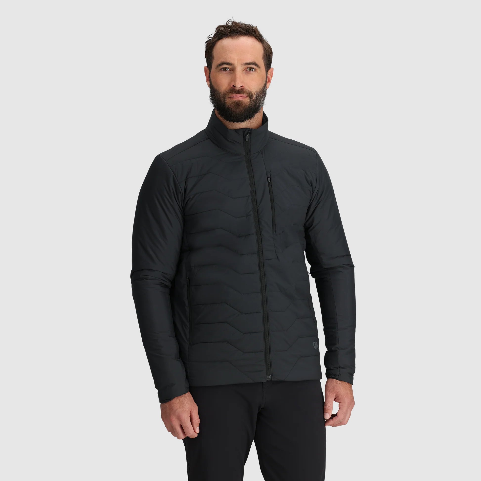 Man wearing a black quilted jacket on a light gray background