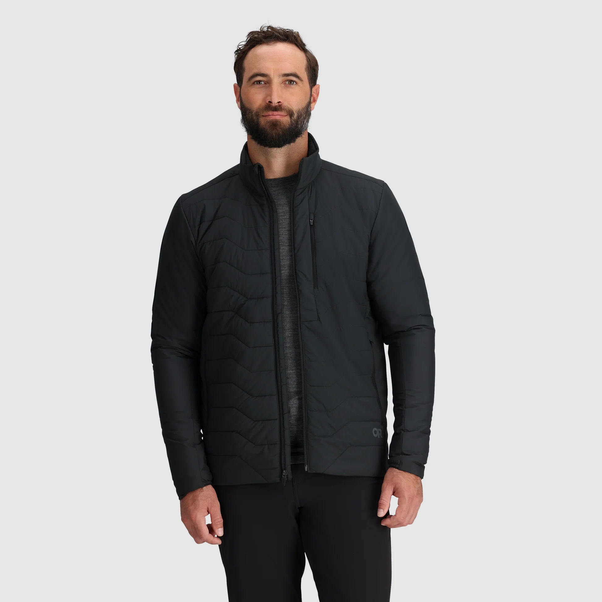 Man wearing a black quilted jacket on a light gray background