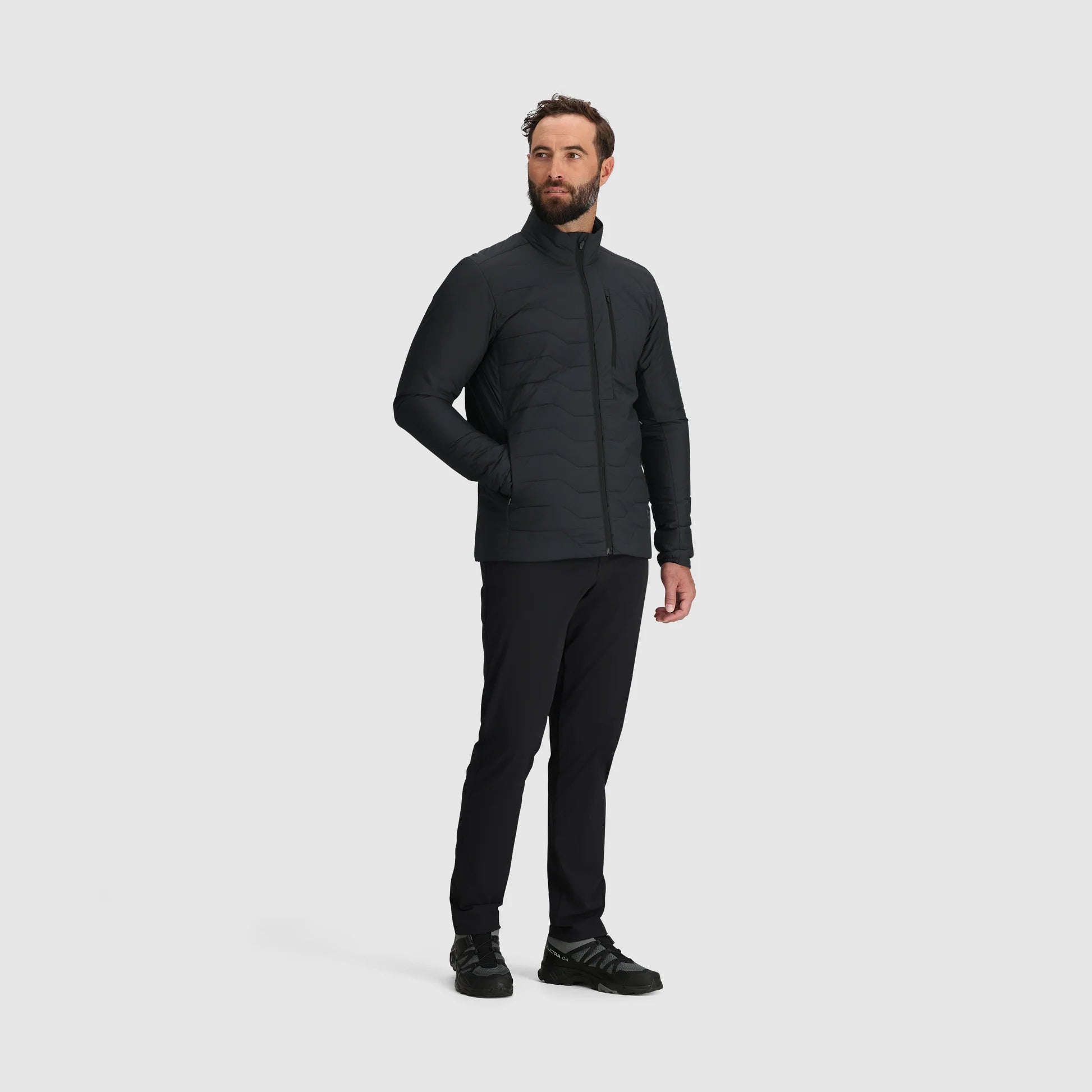 Man wearing a black jacket and pants on a white background
