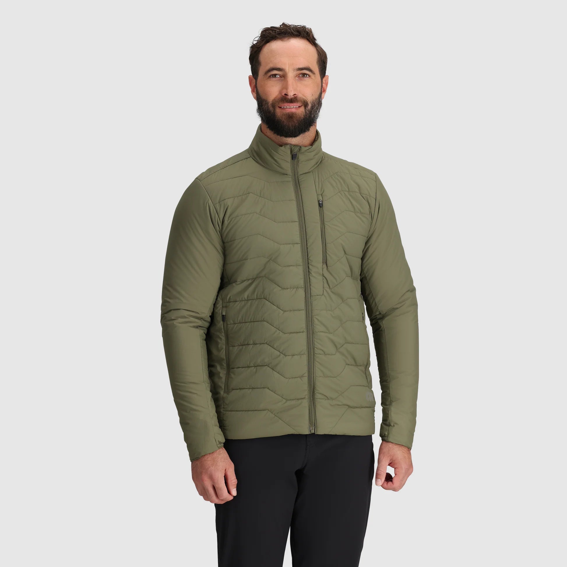 Man wearing a green quilted jacket on a light gray background