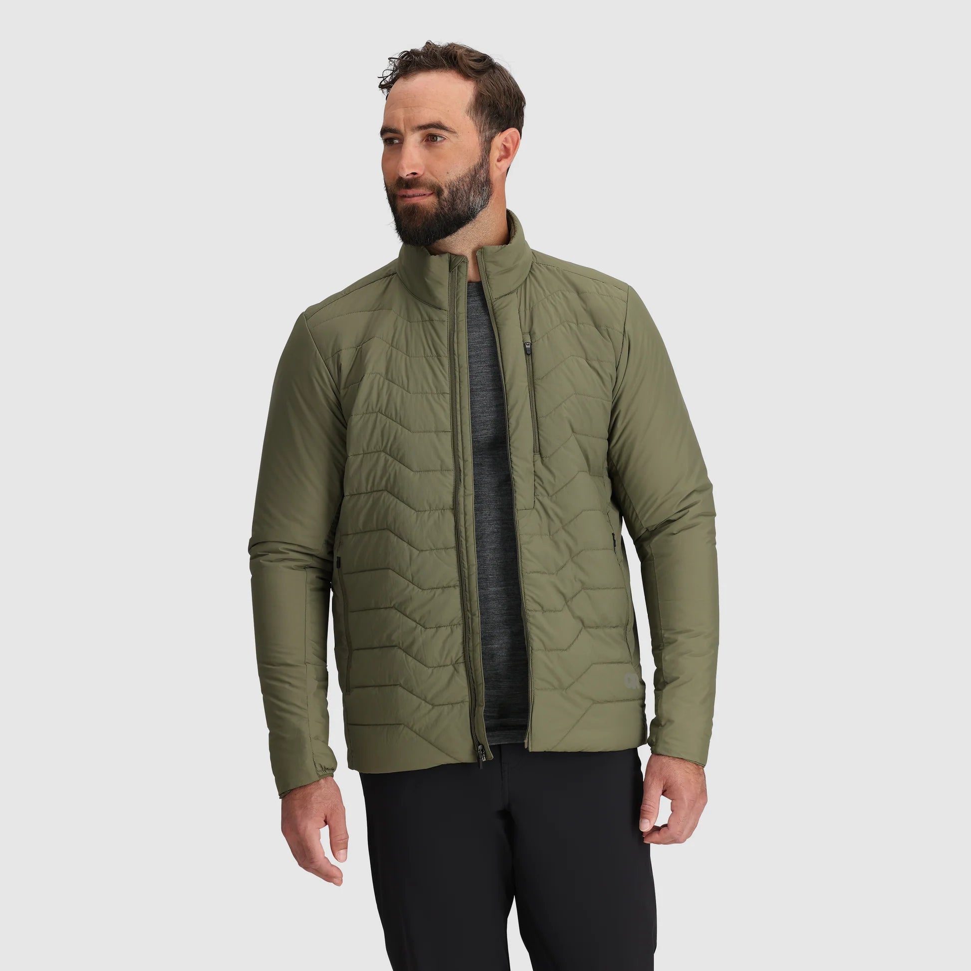 Man wearing a green quilted jacket on a gray background