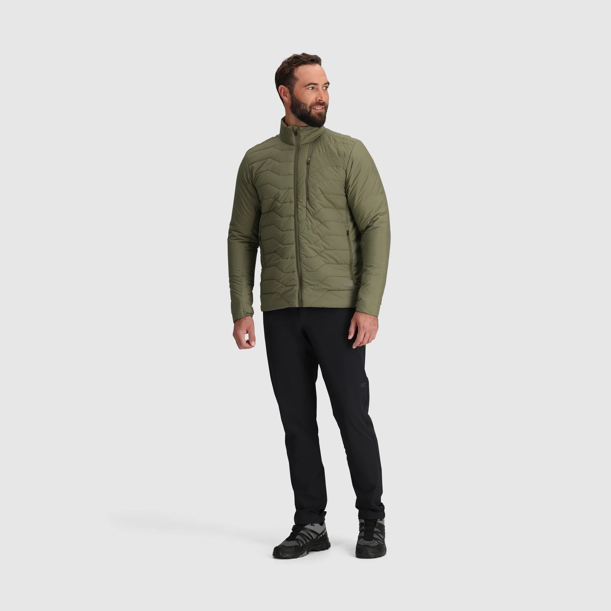 Man wearing a green quilted jacket on a white background