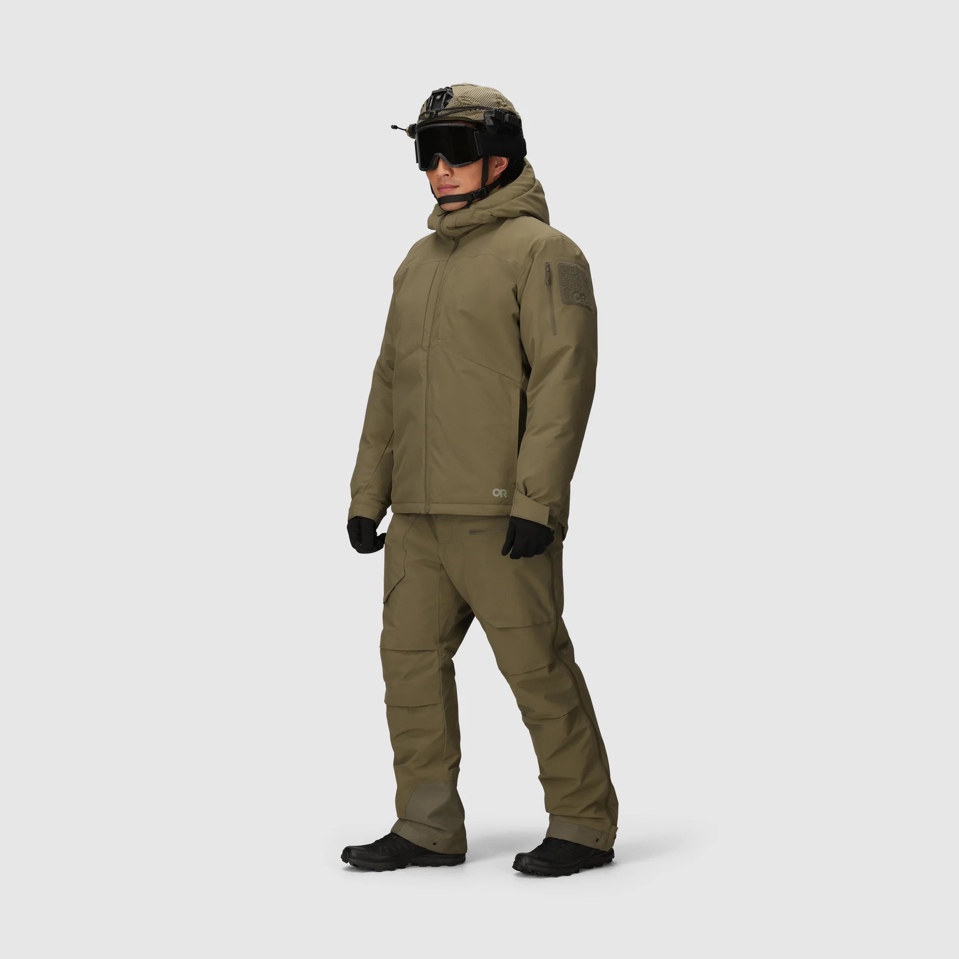 Person wearing a full olive green military-style outfit on a white background