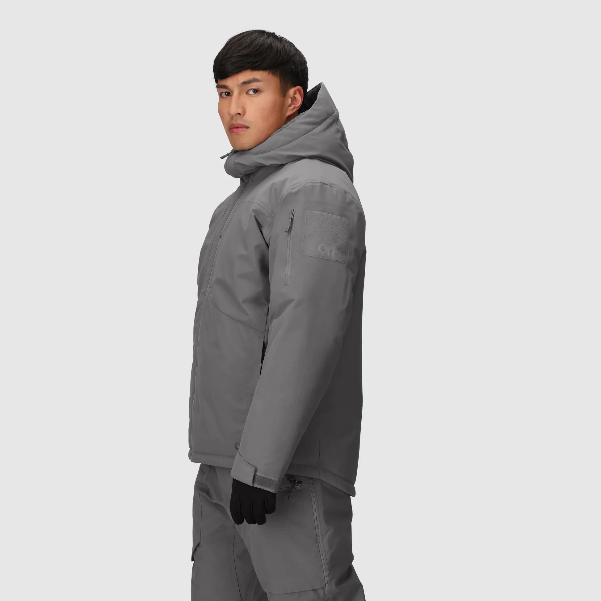 Person wearing a gray snowsuit on a light gray background