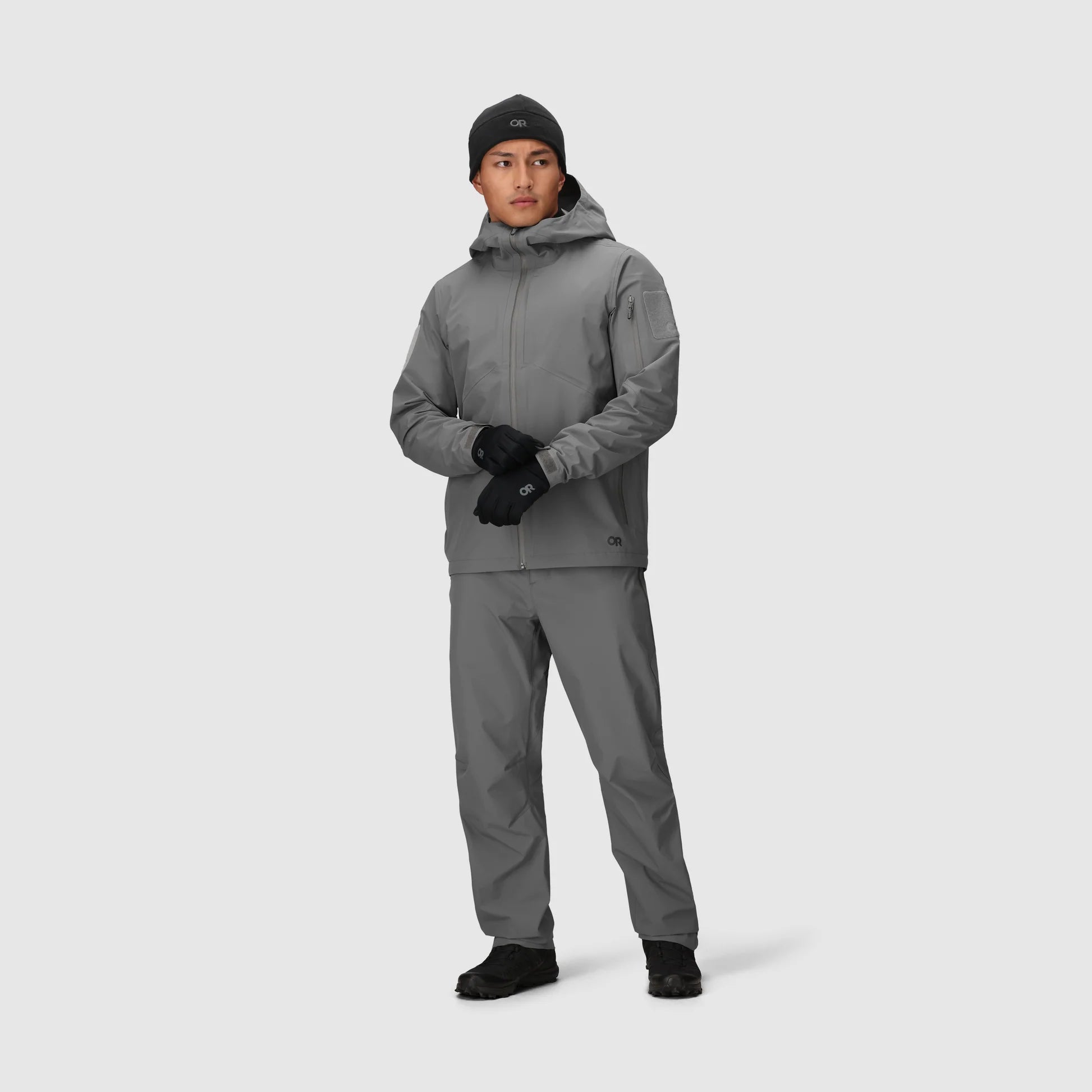 Person wearing a gray winter jacket and pants on a white background