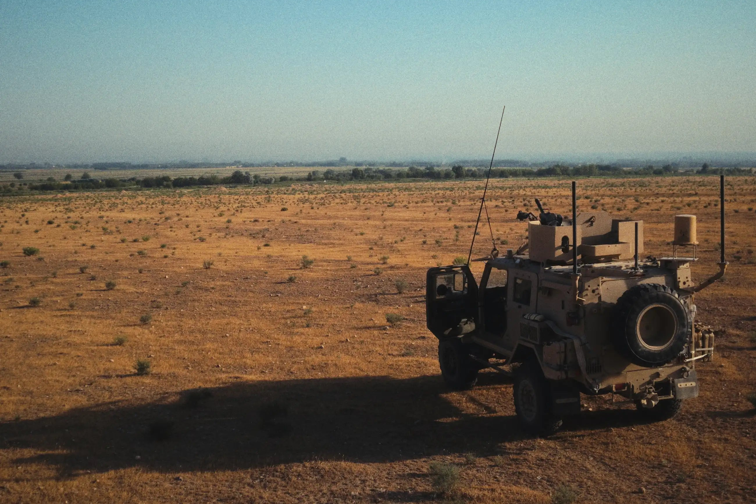 Military vehicle in a desert landscape with clear sky